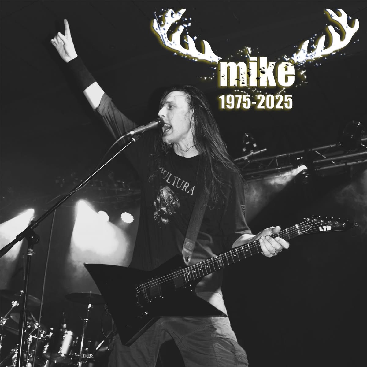 Offizielles Gedenkbild der Band: Mike live am Mikrofon, Horns up, mit Geweih-Grafik und „mike · 1975–2025“.